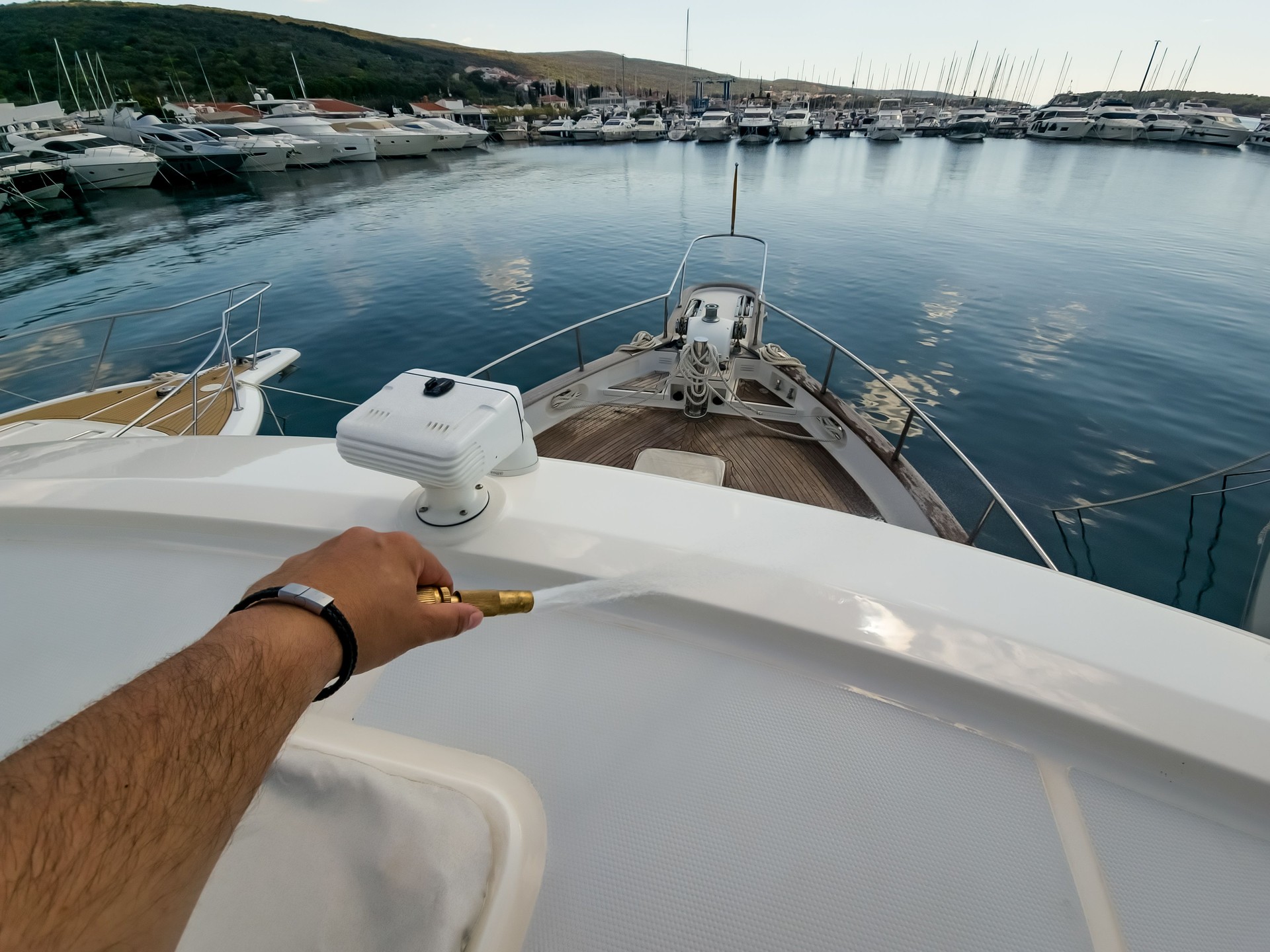 Latino Man Cleaning Boat Deck in Marina